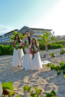 Novia con dos niñas de flores durante una boda en la playa de Punta Cana