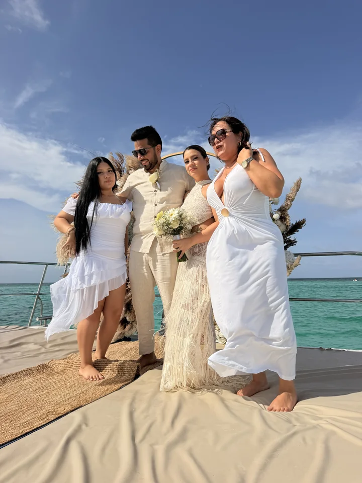 Recién casados celebrando con su familia después de una ceremonia privada en catamarán en Punta Cana