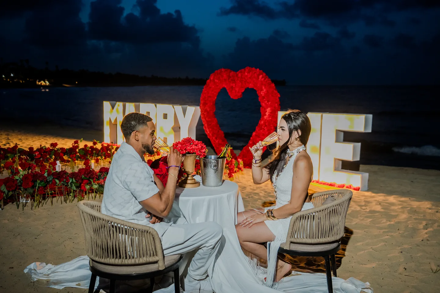 Casal celebrando em um jantar de pedido na praia