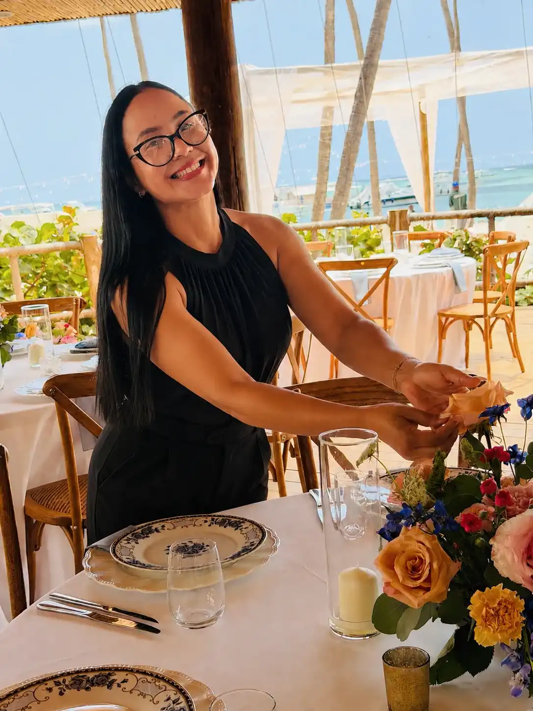 Grecia Mejía arranging a beachfront wedding table in Punta Cana