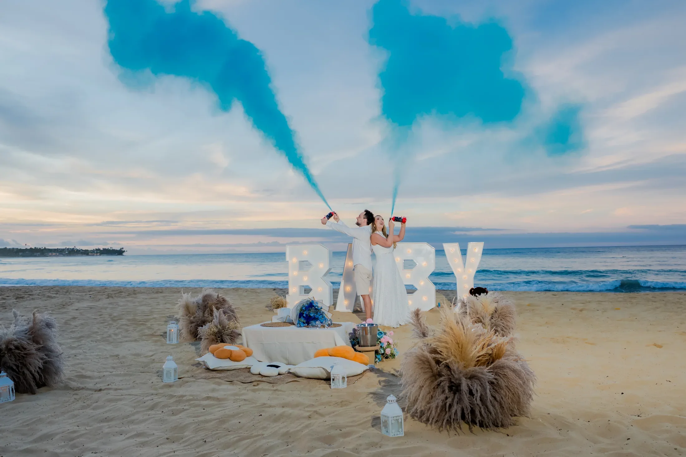 Blue smoke gender reveal celebration on a Punta Cana beach